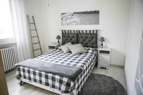 1 dormitorio con cama a cuadros en blanco y negro en Appartamento al Birrificio, en Valeggio sul Mincio