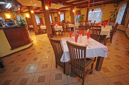 un comedor con mesas y sillas en un restaurante en Imola Motel, en Gheorgheni