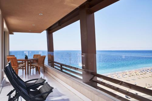 a balcony with a table and chairs and the ocean at Bellevue On The Beach Suites in Rhodes Town