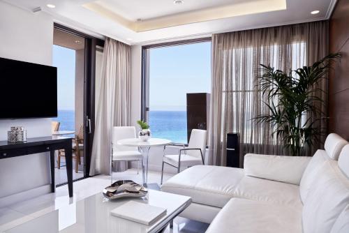 a living room with a white couch and a table at Bellevue On The Beach Suites in Rhodes Town