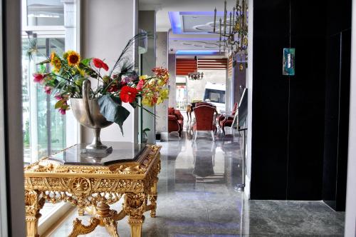 a room with a table with a vase of flowers on it at Grand Atakum Hotel in Samsun
