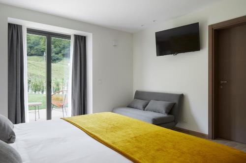 a bedroom with a bed and a couch and a television at Oribar Casa Rural in Aia