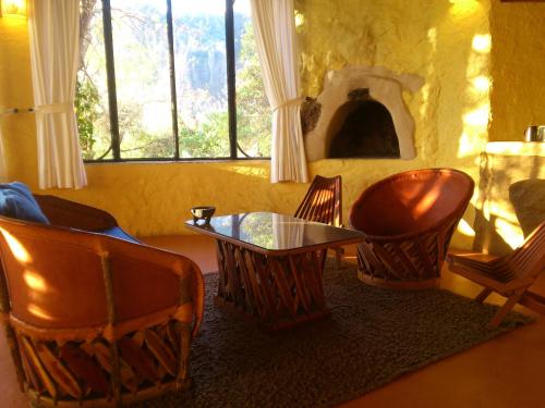 a living room with chairs and a table and a window at Hotel Valle Místico in Tepoztlán