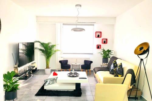 un salon avec un canapé jaune et une table dans l'établissement LE LOVELYHOME au Centre ville avec SPA JACUZZI et SAUNA proche gare et parking gratuit, à Colmar