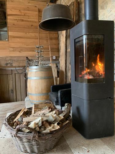 a wood stove with a fire in a room at Logis Hotel Nature Cathare in Léran