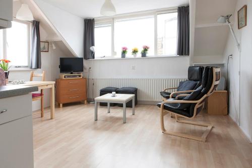 a living room with a table and chairs and a kitchen at Appartement Zuidstraat Domburg in Domburg