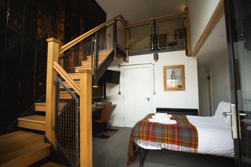 a bedroom with a bed and a spiral staircase at Owen House Farm in Knutsford