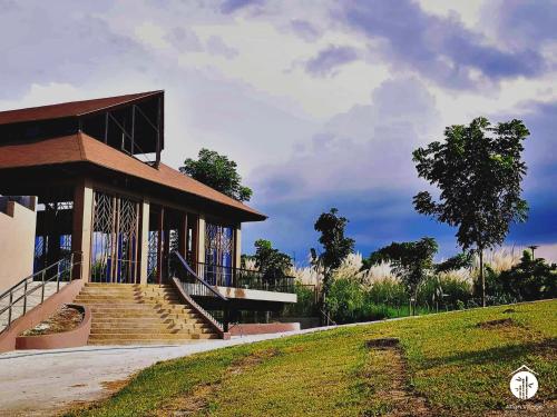 a building with stairs in front of a grass field at Asian Village Tagaytay in Tagaytay
