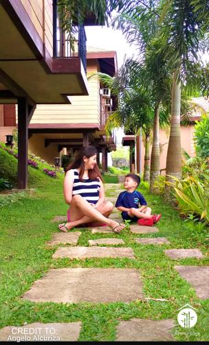 a woman and a child sitting on the grass at Asian Village Tagaytay in Tagaytay