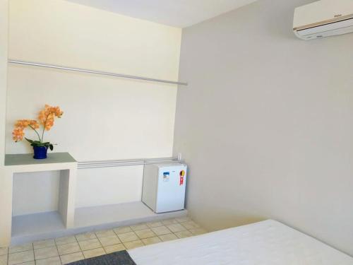 a white room with a counter and a refrigerator at Hotel de Trânsito da PM-PE in Olinda