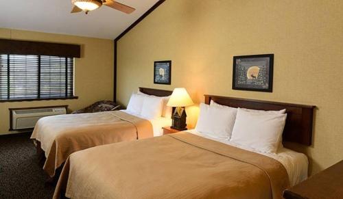 Habitación de hotel con 2 camas y ventana en Boarders Inn & Suites by Cobblestone Hotels in Waukon, en Waukon