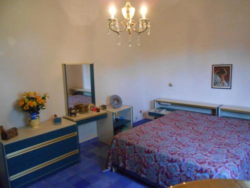 1 dormitorio con cama, espejo y lámpara de araña en Villa Gilda, en Trabia