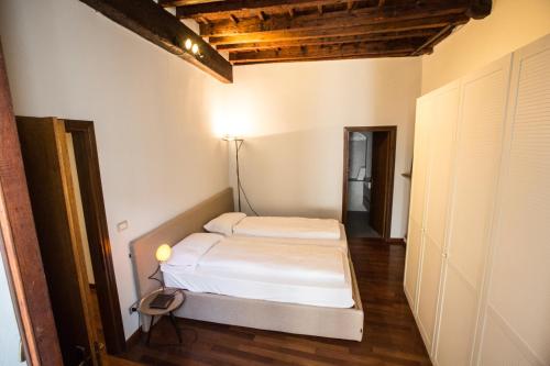 a bedroom with a white bed in a room at Historical apartment in the center of Gravedona - Larihome A02 in Gravedona