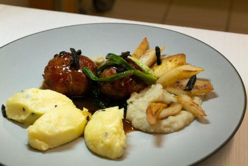 a plate of food with potatoes and vegetables on a table at Auberge du Prévoux in Le Locle