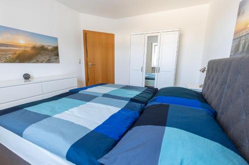 a blue and white bed in a bedroom at Ferienwohnung Garten in Unterneukirchen