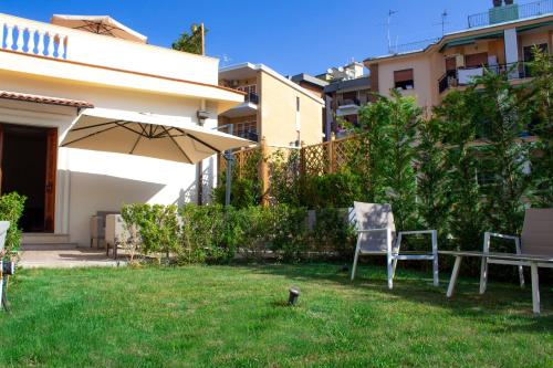 a yard with two chairs and an umbrella at Relais Villa Montedonzelli in Naples