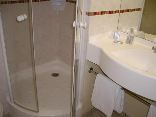 y baño con ducha y lavamanos. en Ace Hotel Brive, en Brive-la-Gaillarde