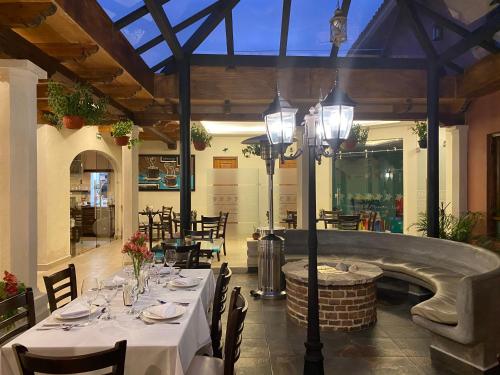 a restaurant with a table with white tables and chairs at Hotel Villa Murano in San Cristóbal de Las Casas