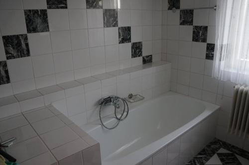 białą wannę z metalowym pierścieniem wokół niej w obiekcie Ferienwohnung Donauauen w mieście Orth an der Donau