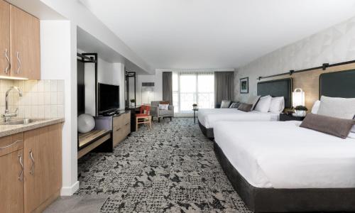 a hotel room with two beds and a television at The Crystal Lodge in Whistler