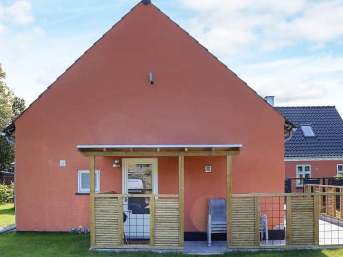 una casa roja con techo de gambrel en 6 person holiday home in Hadsund en Hadsund
