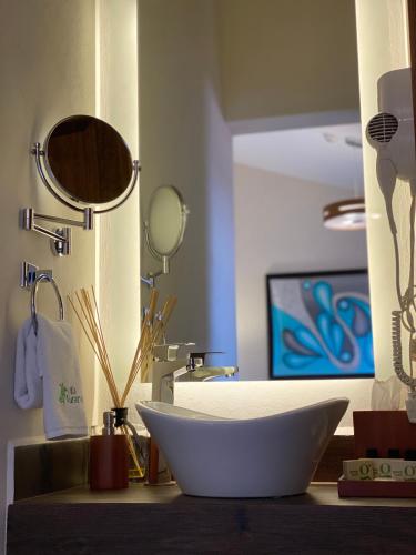 a bathroom with a bowl sink and a mirror at Hotel Villa Murano in San Cristóbal de Las Casas