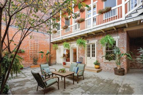 a wooden bench sitting in front of a brick building at French Quarter 3 Bedroom Condo with Balcony in New Orleans