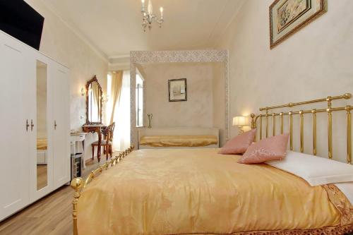 Un dormitorio con una gran cama dorada con almohadas rosas en Just Chilling Suite, en Roma