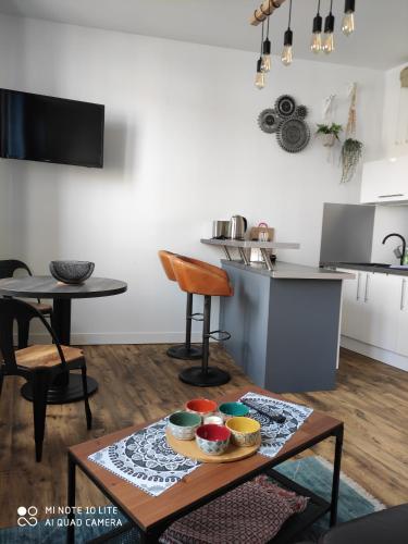 - un salon avec une table et des bols dans l'établissement L' ALBATROS vue sur le port, à Fécamp