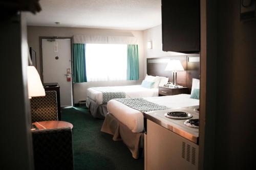 ein Hotelzimmer mit 2 Betten und einem Fenster in der Unterkunft Ramada by Wyndham in Quesnel