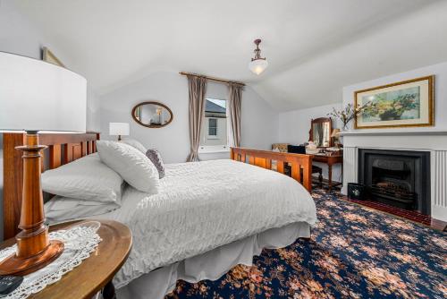a bedroom with a bed and a fireplace at Coopers Cottage Battery Point in Hobart