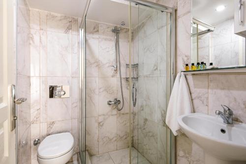 a bathroom with a shower and a toilet and a sink at Hotel Taksimdays in Istanbul