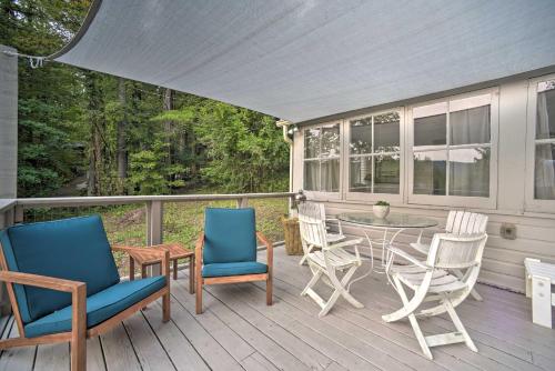 a porch with chairs and a table on a deck at Cozy Stockbridge Cabin - Walk to Beach and Lake! in Stockbridge