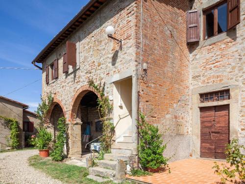 een bakstenen gebouw met een poort en een deur bij Belvilla by OYO Flat in farmhouse with pool in Pian di Scò
