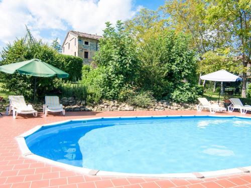 uma piscina com cadeiras e guarda-sóis num quintal em Magnificent Holiday Home in Amandola with 2 Private Pools em Amandola