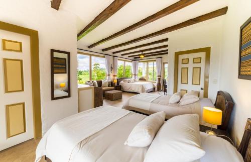 um quarto com 3 camas e uma sala de estar em Hotel Estrella Del Monte em Armenia