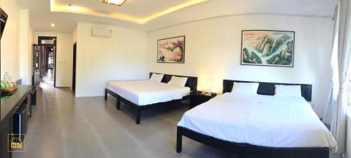 a hotel room with two beds and a table at Phu House in Phu Quoc