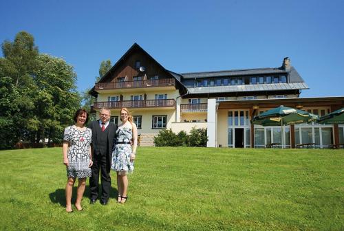 a group of people standing in front of a house at Hotel Haus am Ahorn in Schöneck