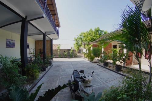 a scooter parked in a courtyard of a house at Watukarung Sackstone Guesthouse in Kalak