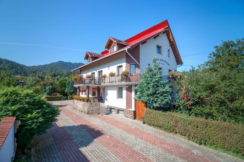 a large white house with a red roof at Casa Din Noua in Braşov