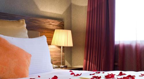 a bedroom with a bed and a lamp and a window at H.M.Hotel in Hsinchu City