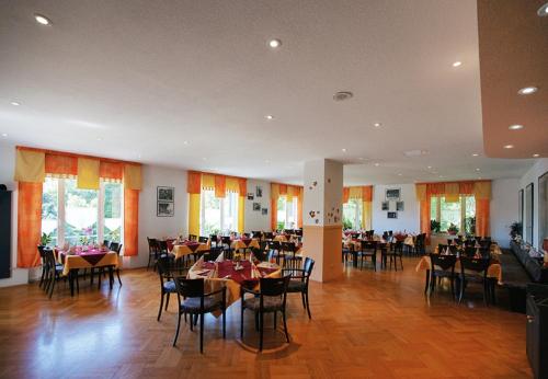 a dining room with tables and chairs in a building at Hotel Haus am Ahorn in Schöneck