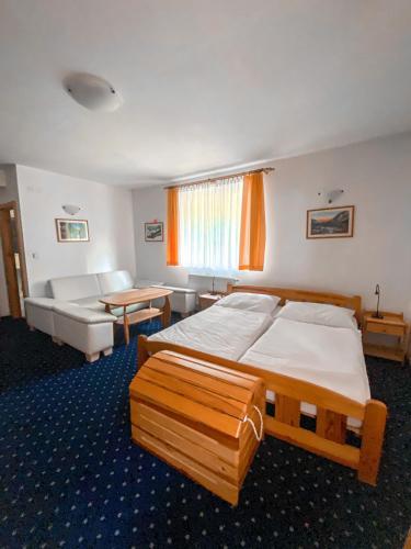 a bedroom with a large bed and a couch at Penzión Teniscentrum in Tatranská Lomnica