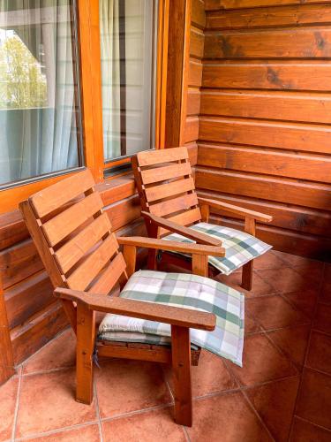 two chairs sitting on the porch of a cabin at Penzión Teniscentrum in Tatranská Lomnica