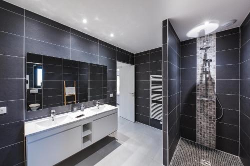 une salle de bain avec deux lavabos et une douche dans l'établissement Petra d'Oro Villa Palombaggia, à Porto-Vecchio