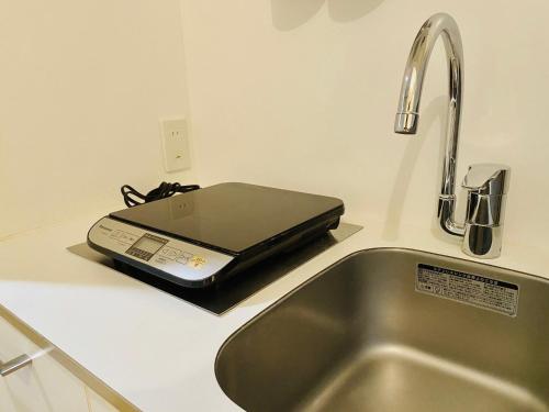 a laptop sitting on a counter next to a sink at Dwell Urban 7C in Tokyo