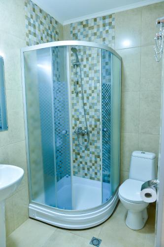 a bathroom with a shower with a toilet and a sink at Happy Stay Hotel in Kutaisi