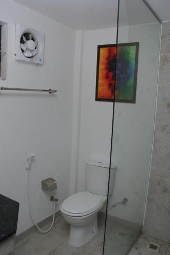 a bathroom with a toilet and a painting on the wall at Hotel Zakaria International in Dhaka