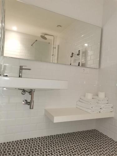 a bathroom with a sink and a mirror and towels at Carrioza Alojamiento Turístico in Parada del Sil