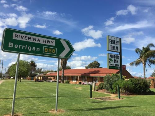 two street signs in front of a building at The Finley Palm Motor Inn in Finley